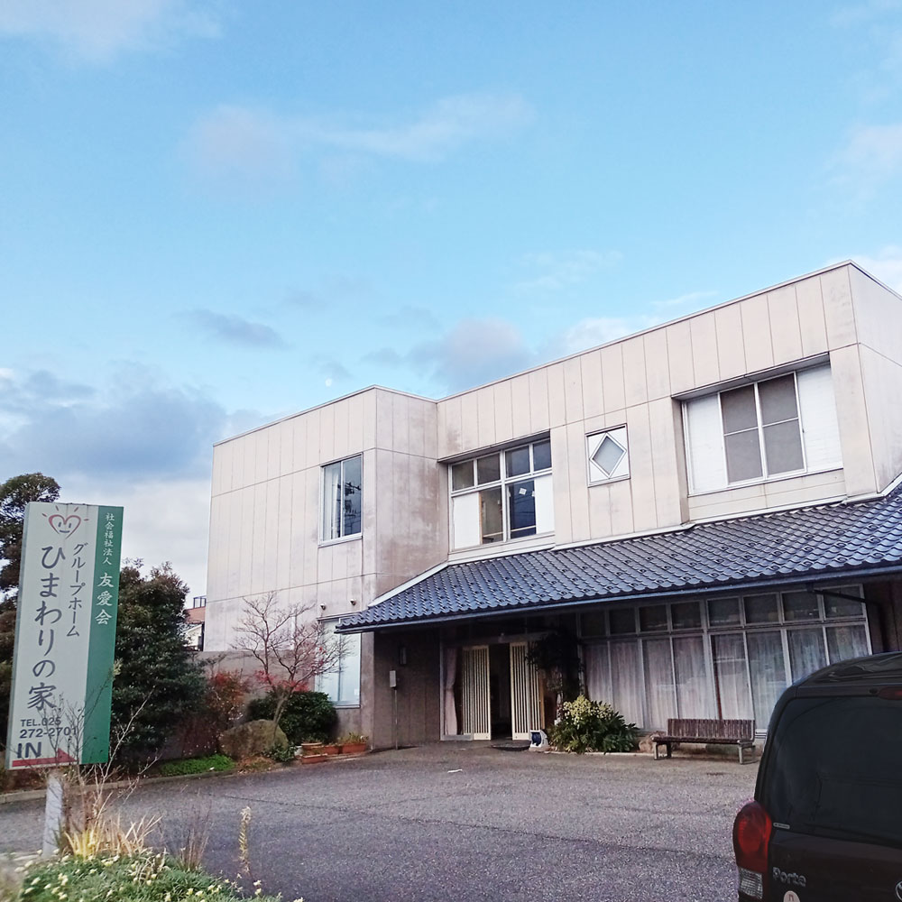 介護施設の建物外観。モダンな白色外壁と伝統的な瓦屋根を組み合わせた設計